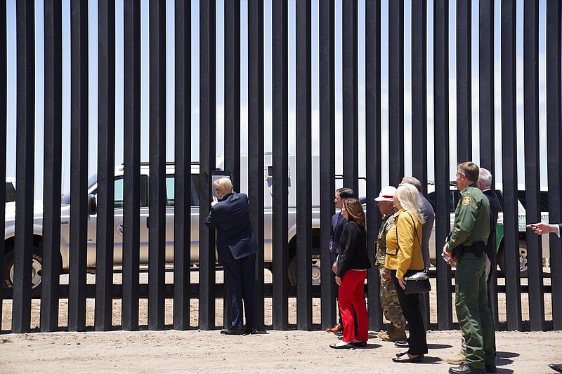 President Donald Trump signs a plaque as he tours a section of the border wall in San Luis, Ariz., in this June 23, 2020, file photo.