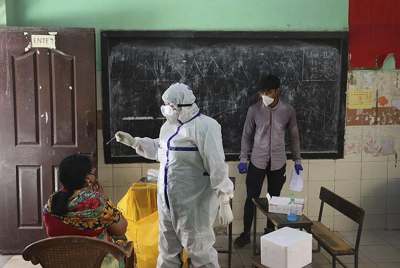 An Indian health worker tests a woman for the coronavirus Wednesday in New Delhi.
(AP/Manish Swarup)