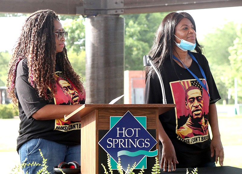 Paris Stevens, left, of Charlotte, N.C., and Angela Harrelson, of Minneapolis, Minn., listen while being introduced at an Arkansas Martin Luther King, Jr. Commission “Get Out to Vote” event Saturday evening at the Hot Springs Farmers & Artisans Market. - Photo by Richard Rasmussen of The Sentinel-Record story.lead_photo.caption
