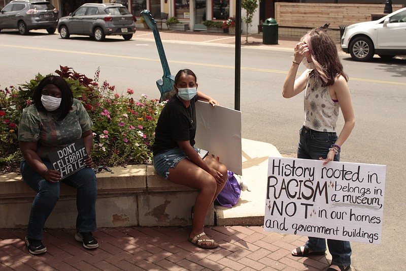 Erica Hinton, Maria Lopez and Abigail Jerry, who demonstrated in opposition to the Confederate monument at the Union County Courthouse and a pro-monument demonstration earlier Saturday morning, speak late Saturday morning. (Caitlan Butler/News-Times)