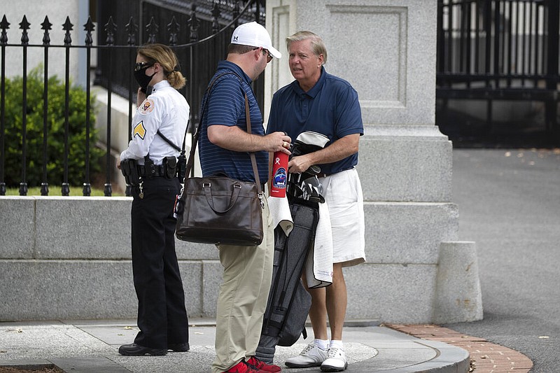 U.S. Sen. Lindsey Graham (right), R-S.C., grabs his golf bag upon returning to the White House in Washington on Sunday, June 28, 2020, from Trump National Golf Club in Virginia, where he golfed with President Donald Trump. Graham said Saturday that it was “imperative Congress get to the bottom of” the story that a Russian military intelligence unit secretly offered bounties to Taliban-linked militants for killing American troops in Afghanistan.