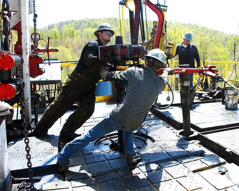 Workers move a section of well casing into place at a Chesapeake Energy natural gas well site near Burlington, Pa., in this April 23, 2010, file photo. Chesapeake Energy, a shale drilling pioneer that helped to turn the United States into a global energy powerhouse, has filed for bankruptcy protection. The Oklahoma City-based company said Sunday, June 28, 2020, that it was a necessary decision given its debt load of nearly $9 billion.