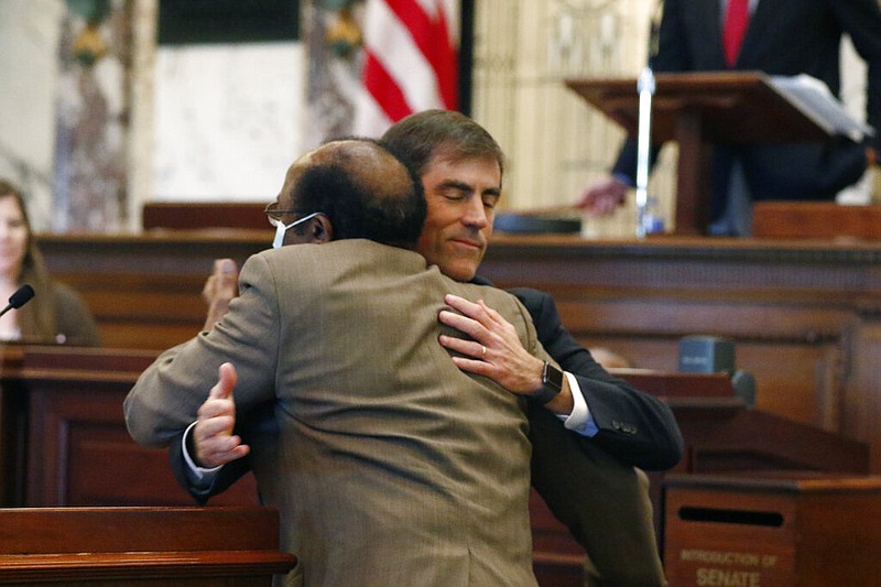 Mississippi state Sen. Briggs Hopson (face to camera), R-Vicksburg, is hugged by state Sen. Albert Butler, D-Port Gibson, after the state Senate voted Sunday, June 28, 2020, at the Capitol in Jackson to change the state flag. Hopson presented the bill to the body. Republican Gov. Tate Reeves has said he will sign the bill, which would immediately strip the state flag of its official status.