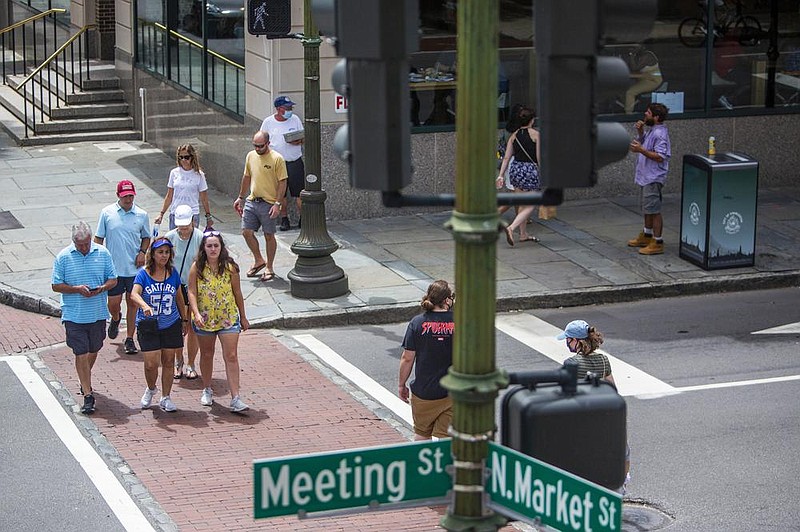 Pedestrians, many without masks, walk around Saturday in downtown Charleston, S.C. The biggest spikes in coronavirus infections have been seen in the West and South.
(The New York Times/Gavin McIntyre) story.lead_photo.caption