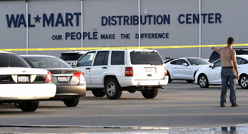 Crime tape blocks off a parking lot outside the Red Bluff, Calif., Walmart Distribution Center where the shooting’s suspect and an employee were killed Saturday and four others were injured. (AP/The Record Searchlight/Mike Chapman) 
