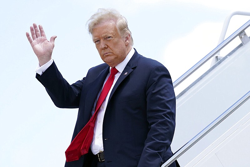 In this Thursday, June 25, 2020 file photo, President Donald Trump waves as he arrives on Air Force One at Austin Straubel International Airport in Green Bay, Wis. Iran has issued an arrest warrant and asked Interpol for help in detaining President Donald Trump and dozens of others it believes carried out the drone strike that killed a top Iranian general in Baghdad early this year. That's according to a prosecutor in Tehran who was quoted by to state-run IRNA news agency on Monday, June 29, 2020. The prosecutor said Iran had asked Interpol to issue a “red notice” for Trump and over 30 others. (AP Photo/Evan Vucci, File)