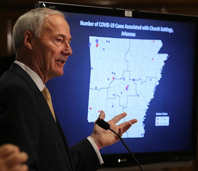 Gov. Asa Hutchinson shows a breakdown of covid-19 cases associated with church settings during the daily covid-19 briefing on Friday, June 26, 2020, at the state Capitol in Little Rock. 