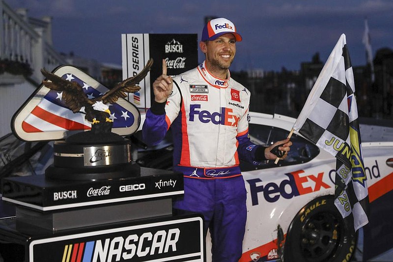 Denny Hamlin smiles after winning Sunday’s NASCAR Cup Series race at Pocono Raceway in Long Pond, Pa. Hamlin held off Kevin Harvick for his fourth victory of the season and sixth at Pocono. (AP/Matt Slocum) 
