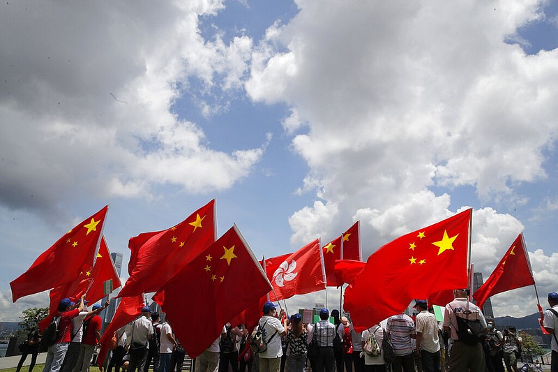 Pro-China supporters hold Chinese and Hong Kong national flags during a rally to celebrate the approval of a national security law for Hong Kong, in Hong Kong, Tuesday, June 30, 2020. Hong Kong media are reporting that China has approved a contentious law that would allow authorities to crack down on subversive and secessionist activity in Hong Kong, sparking fears that it would be used to curb opposition voices in the semi-autonomous territory. (AP Photo/Kin Cheung)
