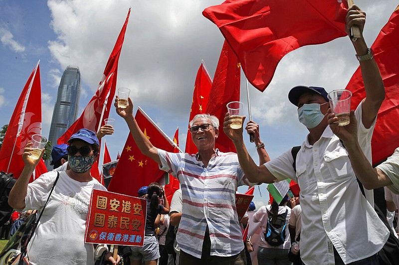 Pro-China supporters holding Chinese national flags, toast during a rally to celebrate the approval of a national security law for Hong Kong, in Hong Kong, Tuesday, June 30, 2020. story.lead_photo.caption