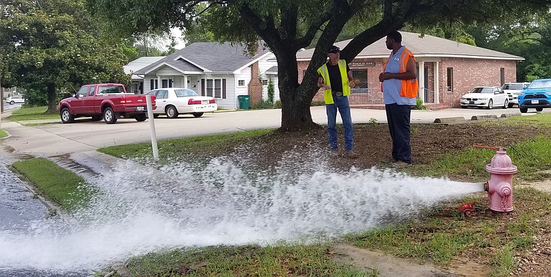 El Dorado public workers examine a fire hydrant with a broken valve on Faulkner Street on Tuesday, June 30. (Caitlan Butler/News-Times)