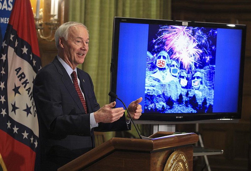 Gov. Asa Hutchinson speaks Tuesday June 30, 2020 at the state Capitol in Little Rock during his daily covid-19 briefing about the importance of wearing a mask this holiday weekend as he shows an image of the presidents at Mt. Rushmore with wearing masks. See more photos at arkansasonline.com/71governor/.  (Arkansas Democrat-Gazette/Staton Breidenthal)