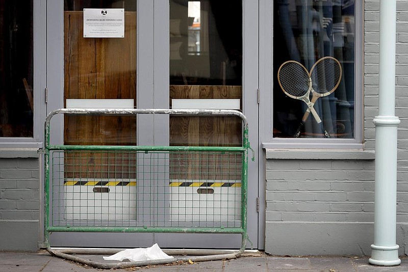 Two tennis rackets are propped in the window of a closed pub Monday in London. Due to have started Monday, Wimbledon was canceled because of the coronavirus pandemic, marking the first time since World War II that the tournament won’t take place. (AP/Kirsty Wigglesworth) 
