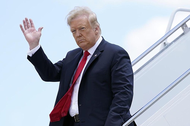 ADDS THAT IRNA IS STATE-RUN: FILE - In this Thursday, June 25, 2020 file photo, President Donald Trump waves as he arrives on Air Force One at Austin Straubel International Airport in Green Bay, Wis. Iran has issued an arrest warrant and asked Interpol for help in detaining President Donald Trump and dozens of others it believes carried out the drone strike that killed a top Iranian general in Baghdad early this year. That's according to a prosecutor in Tehran who was quoted by to state-run IRNA news agency on Monday, June 29, 2020. The prosecutor said Iran had asked Interpol to issue a â€œred noticeâ€ for Trump and over 30 others. (AP Photo/Evan Vucci, File)