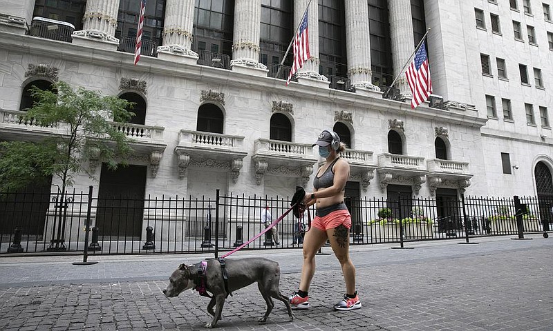 A woman walks her dog past the New York Stock Exchange, where investors on Tuesday picked up their last gains of the quarter. (AP/Mark Lennihan) 