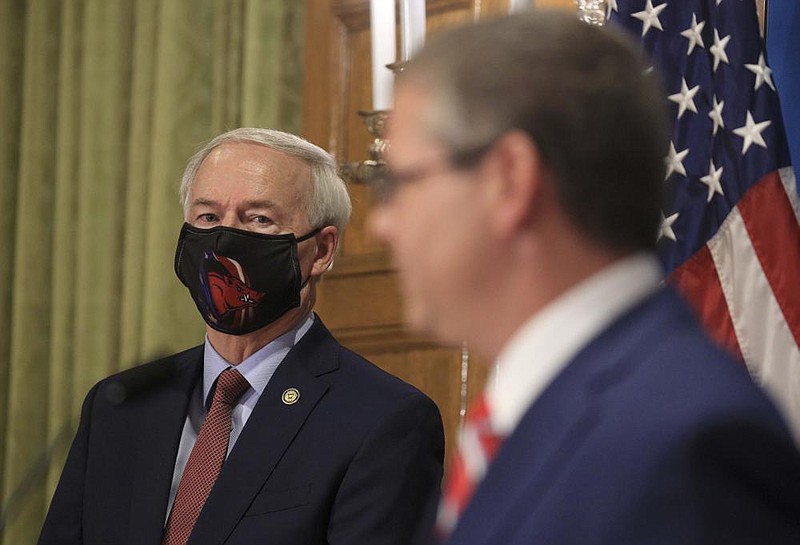 Gov. Asa Hutchinson, left, listens to Sec. of State John Thurston speak about absentee ballots Thursday July 2, 2020 at the state Capitol in Little Rock during the daily covid-19 briefing. (Arkansas Democrat-Gazette/Staton Breidenthal)