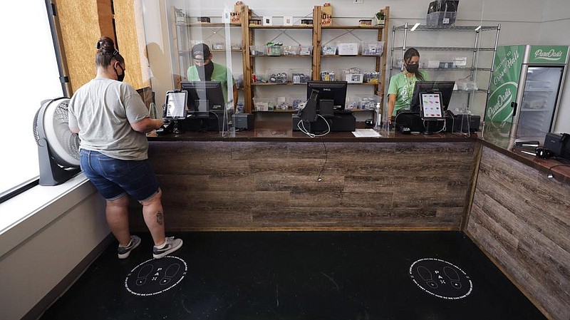 Kerri Thibodeau of Stoughton, Mass., makes a purchase last week at Pure Oasis, a Black-owned recreational marijuana dispensary in the Grove Hall neighborhood of Boston.
(AP/Charles Krupa)