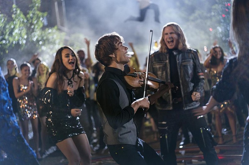 Mita (Melissanthi Mahut) and Lars Erickssong (Will Ferrell) watch as Belarusian-Norwegian singer-composer-violinist Alex Ryback performs in “Eurovision Song Contest: The Story of Fire Saga.” In real life, Ryback won the 2009 Eurovision contest with the highest score in history for his song “Fairytale.”