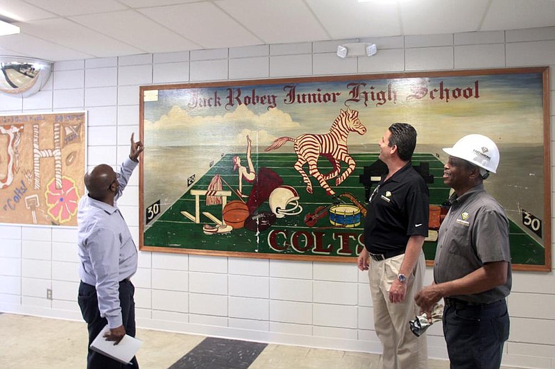 Pine Bluff School District chief operating officer Leroy Harris (from left) looks over an area of the school’s main hallway with Win Trafford and Carl Banks, both of East Harding Construction, after crews installed new ceiling tiles and painted the walls.
(Arkansas Democrat-Gazette/Dale Ellis)