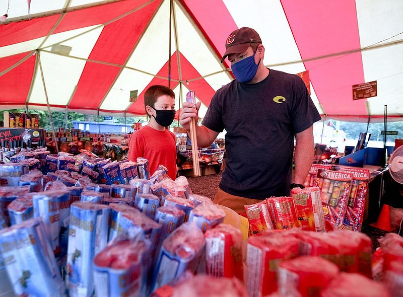 Jason Lynch and his son, Connor, 9, look through bottle rockets Thursday at Deaton Fireworks on Arkansas 365 outside Maumelle.
(Arkansas Democrat-Gazette/Thomas Metthe)