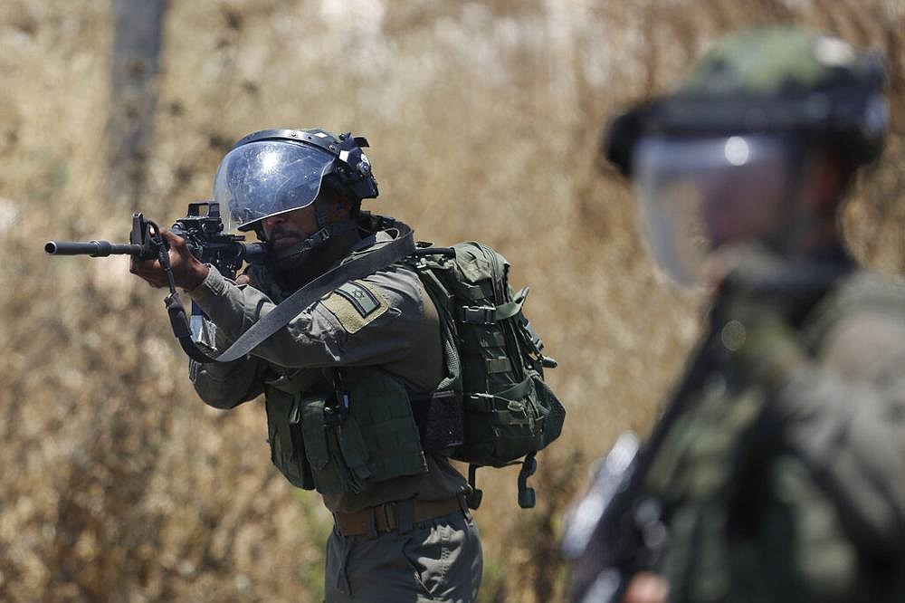 Palestinian demonstrators hurl stones at Israeli troops during a ...