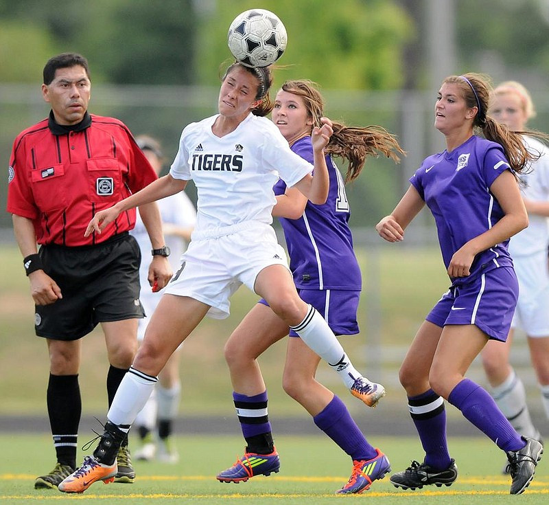 STAFF PHOTO MARC F. HENNING
Bentonville's Tayler Estrada, left, heads the ball Friday, May 4, 2012, in front of Fayetteville's Taylor Hightower, right, and Taylor Ward during the first half of the Lady Tigers' game against the Lady Bulldogs in Bentonville.