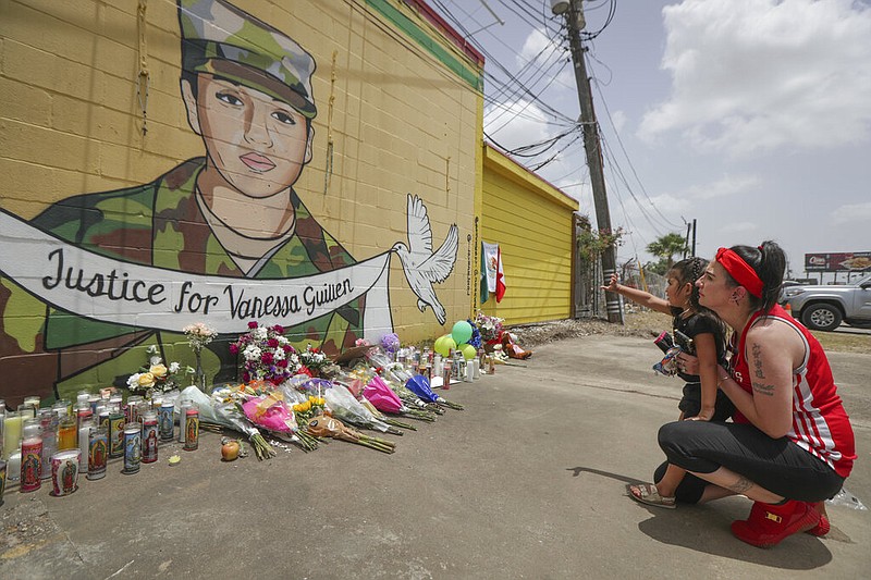Dawn Gomez holds her 3-year-old granddaughter, Saryia Greer, on Thursday, July 2, 2020, while the girl waves at Vanessa Guillen's mural painted by Alejandro "Donkeeboy" Roman Jr. on the side of Taqueria Del Sol in Houston. Army investigators believe Guillen, a Texas soldier missing since April, was killed by another soldier on the Texas base where they served, the attorney for the missing soldier's family said Thursday.