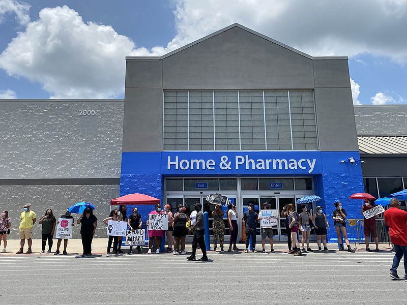 Protesters hold signs outside the Jacksonville Walmart, Sunday, July 5, 2020.