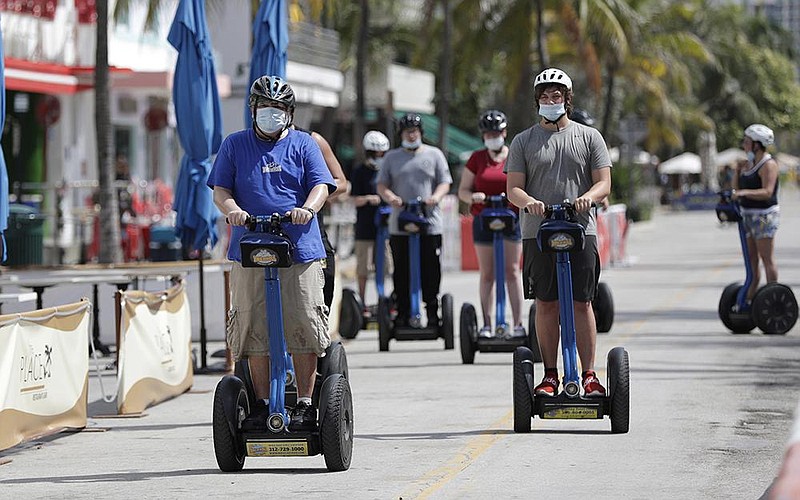 A tour group on Segways rides Saturday along Ocean Drive on South Beach in Miami Beach, Fla. Florida reported 11,445 confi rmed coronavirus cases Saturday. More photos at arkansasonline.com/75covid/.
(AP/Wilfredo Lee)