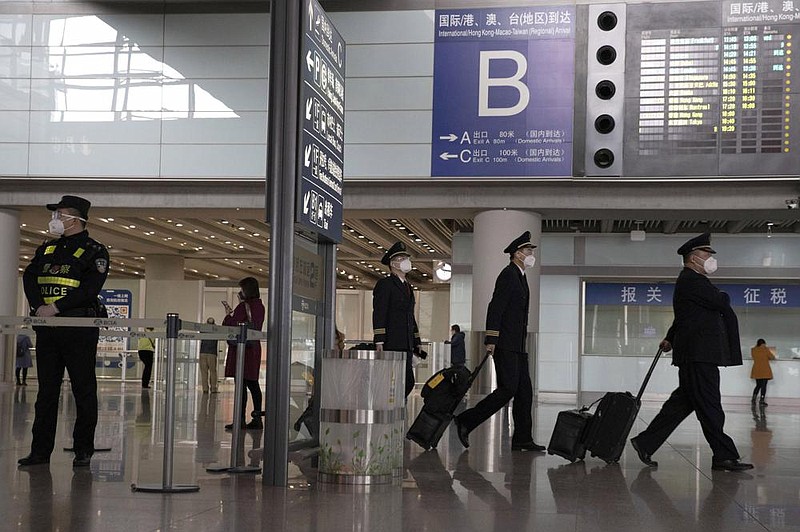 In March, air crew members walk past the international arrivals exit at the Capital International Airport in Beijing. President Donald Trump credits his February ban on travelers from mainland China as his signature move against the advance of the pandemic. More photos at arkansasonline.com/75travelban/
(AP/Ng Han Guan)