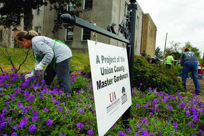 Beautifying: Members of Union County Master Gardeners weed out the garden at El Dorado City Hall in this 2016 file photo. (News-Times file)