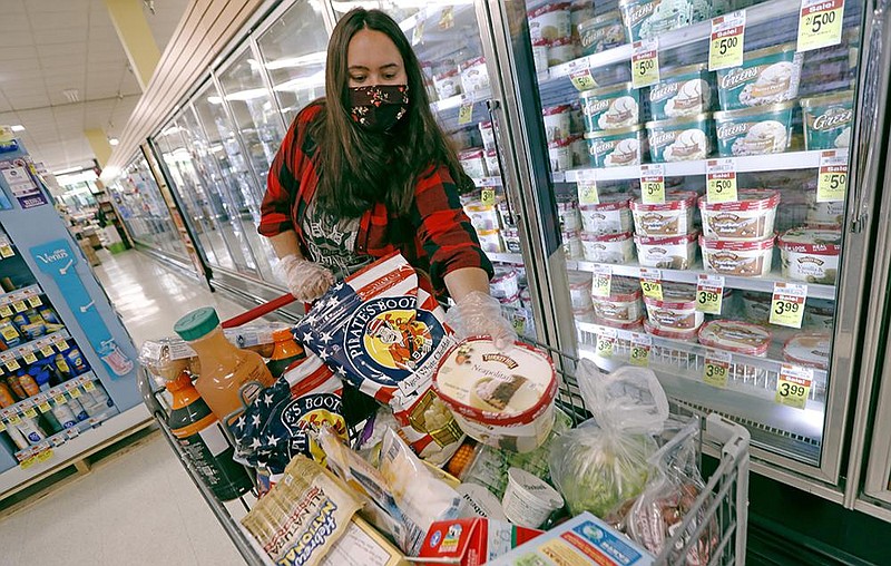 Alexandra Lopez-Djurovic places a container of ice cream into her cart Wednesday as she shops for a client at an Acme market in Bronxville, N.Y. Lopez-Djurovic was working full time as a nanny until her hours were cut substantially, so she started a grocery delivery service to make up for some of her lost wages. More photos at arkansasonline.com/76gigs/. 
(AP/Kathy Willens) 