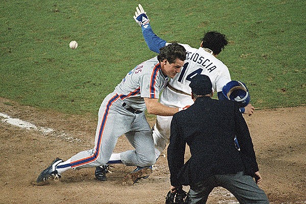 New York Mets Kevin McReynolds, left, is blocked by Los Angeles Dodgers catcher Mike Scioscia (14) as he makes his way to home plate during ninth inning action in Game 1 of the National League Championship Series in Los Angeles, Oct. 5, 1988. Scioscia did not catch the ball and McReynolds scored on the play to lift the Mets past the Dodgers, 3-2. Umpire Harry Wendelstedt watches the play. (AP Photo/Lennox McLendon)