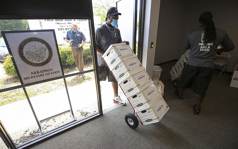 Movers Theo Reed (left) and Joe Mathews unload boxes of signatures from Arkansas Voters First on Monday, July 6, 2020, at the secretary of state’s office in Little Rock. The group was seeking a constitutional amendment that would establish an independent redistricting commission.