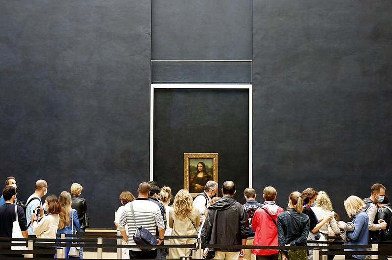 Visitors view the Mona Lisa on Monday as the Louvre Museum in Paris reopened after a four-month coronavirus lockdown. More photos at arkansasonline.com/77louvre/. (AP/Thibault Camus) 
