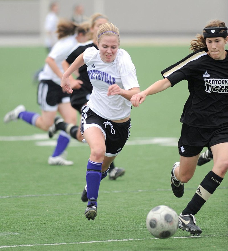 ANDY SHUPE Northwest Arkansas Times
Fayetteville sophomore Anne Mitchell, left, and Bentonville sophomore Margaret Power pursue the ball during the second half of play Friday at Harmon Field.