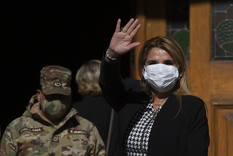 Bolivia's interim President Jeanine Anez, wearing a face mask to help curb the spread of the new coronavirus, waves during a procession in La Paz, Bolivia, in this June 11, 2020, file photo. Anez announced on Thursday, July 9, 2020, that she has tested positive for covid-19.