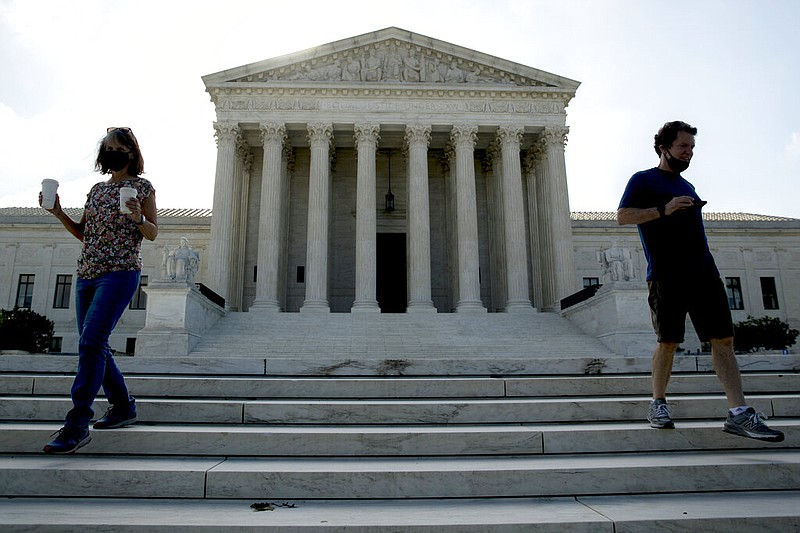 Two people walk down the steps outside the Supreme Court, Thursday, July 9, 2020, in Washington.