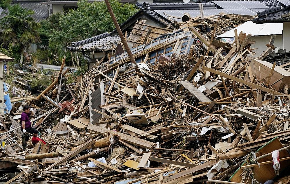 A man surveys the damage to his house and the neighborhood Wednesday after heavy rains in Kuma village in southern Japan. Authorities were searching for people still missing in the region.
(AP/Kyodo News/Koji Harada)