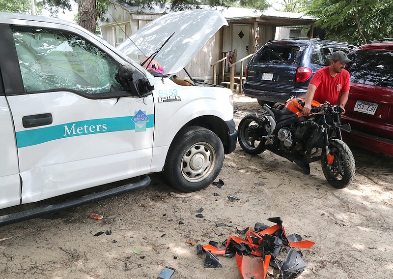 Burks & Mahoney wrecker service employee Mike Shaffer rolls a Honda CBR motorcycle to a waiting flatbed at 173 Charming Heights Drive Friday.