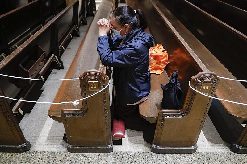 A member of Saint Bartholomew Roman Catholic Church in Queens, N.Y., prays in the church’s nearly empty pews Monday.
(AP/John Minchillo)