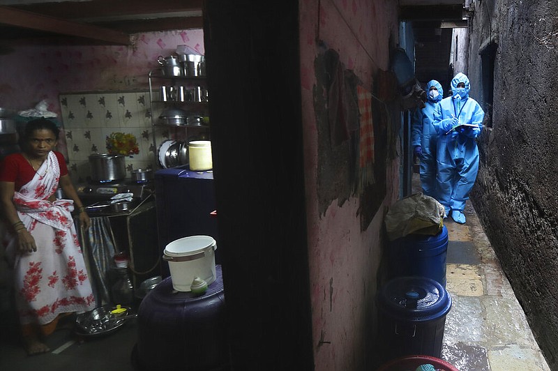 Health workers screen people for COVID-19 symptoms at a slum in Mumbai, India, Tuesday, July 14, 2020. Several Indian states imposed weekend curfews and locked down high-risk areas as the number of coronavirus cases surged past 900,000 on Tuesday. 