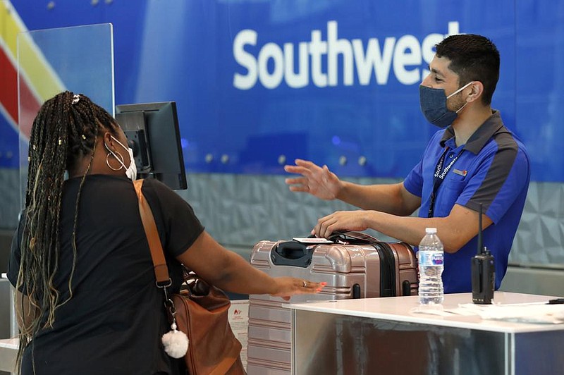 A Southwest Airlines employee helps a passenger last month at the ticket counter at Love Field in Dallas. (AP) 