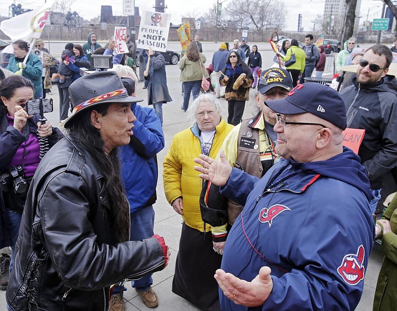 Philip Yenyo (left), executive director of the American Indians Movement for Ohio, talks with a Cleveland Indians fan before a baseball game in 2015. The Cleveland Indians are one of several professional franchises that could be facing scrutiny as to whether it should change its nickname. (AP/Mark Duncan) 