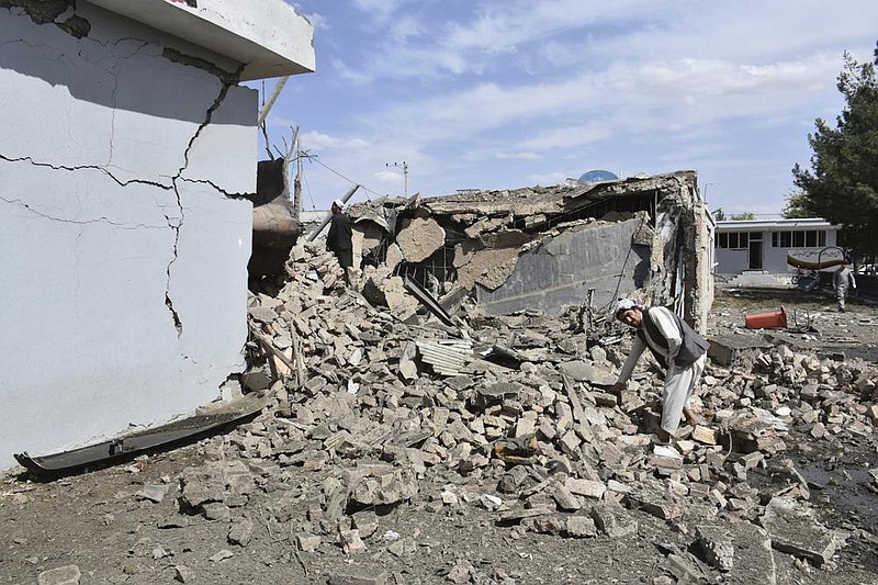 A man examines the spot where a car bomb detonated Monday at the intelligence compound in Aybak, Afghanistan. (AP) 