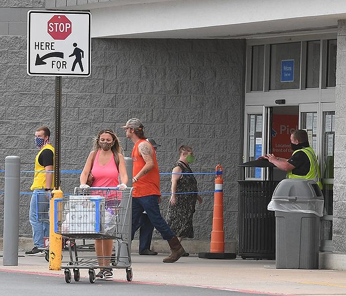 Customers wearing masks enter and exit a Walmart Supercenter in Fayetteville Wednesday July 15, 2020. NWA Democrat-Gazette/J.T.WAMPLER 