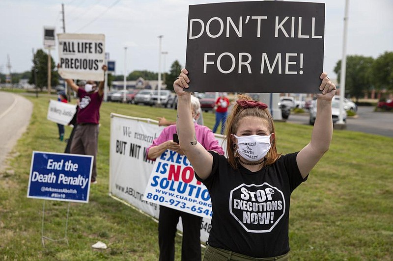 Death-penalty protesters hold up signs on the side of a road Wednesday in Terre Haute, Ind.
(AP/Michael Conroy)