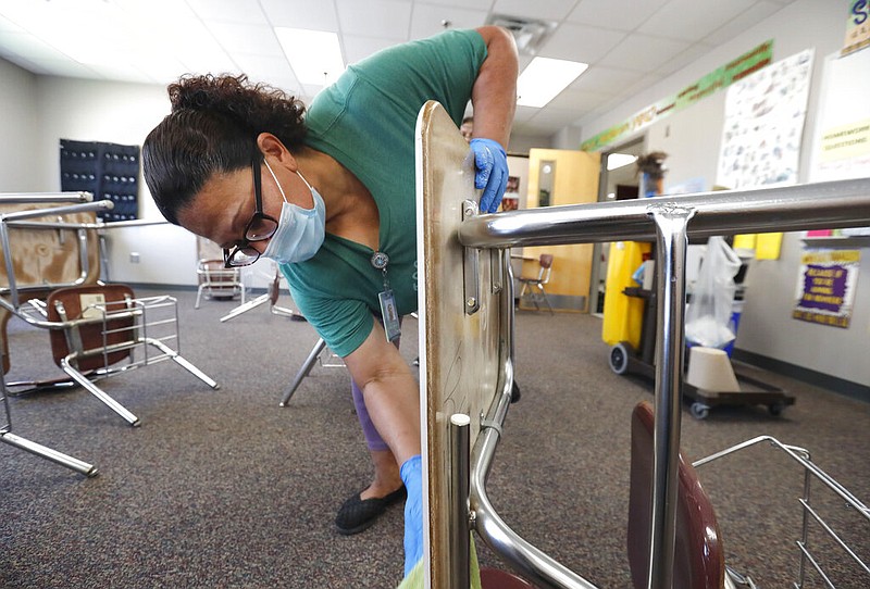 Josefina Median wears a mask as she cleans a classroom at Wylie High School Tuesday, July 14, 2020, in Wylie, Texas. (AP Photo/LM Otero)

