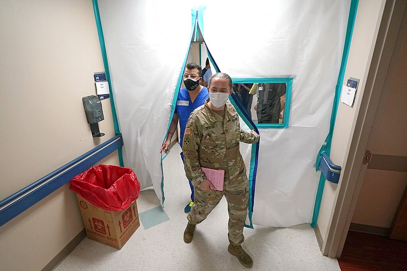 Urban Augmentation Medical Task Force members Army Maj. Katie Bessler, right, and Infectious Disease Physician Maj. Gadiel Alvarado, enter a wing at United Memorial Medical Center, Thursday, July 16, 2020, in Houston. Soldiers will treat covid-19 patients in the newly prepared hospital wing as Texas receives help from across the country to deal with its coronavirus surge. (AP Photo/David J. Phillip)