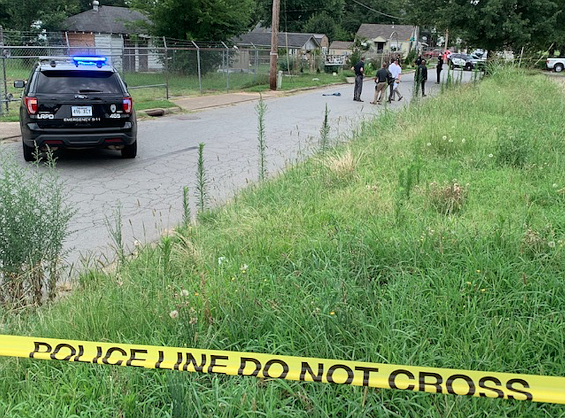 Investigators work Friday in the area of Roosevelt Road and Brown Street, where police said a body was found behind a building. 